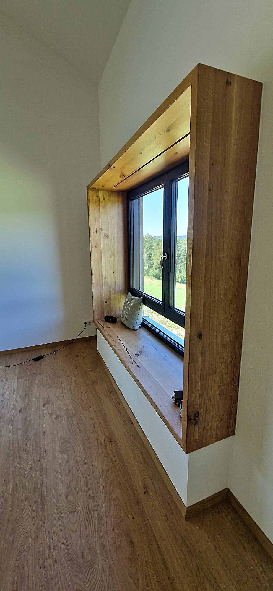 Sitzfenster bzw. Sitzbankfenster, umlaufend aus Eiche massiv gefertigt. Die senkrechten Elemente dienen als Rückenlehne, oben ist Platz als Ablagefläche.